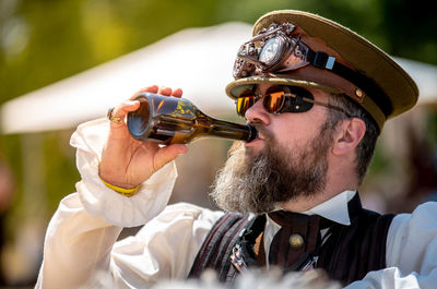 Close-up of man wearing costume while having drink during carnival
