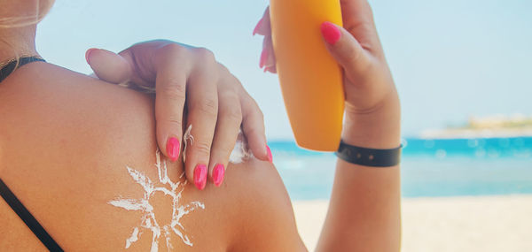 Midsection of woman hands on beach