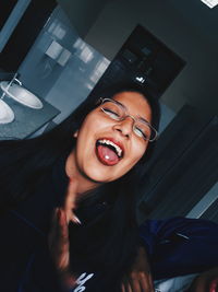 Smiling woman sticking out tongue in bathroom