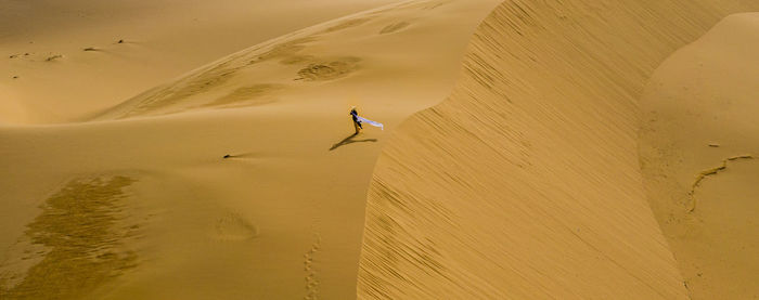 High angle view of a woman wearing ao dai on desert