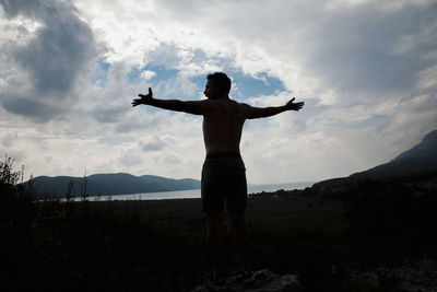 Rear view of silhouette man standing against sky