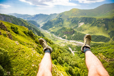 Midsection of man with mountain range