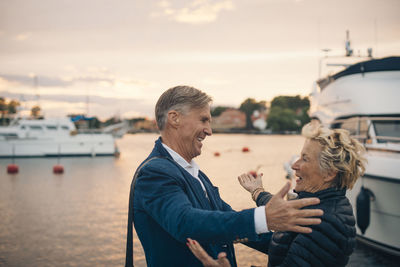 Rear view of man and woman on shore against sky