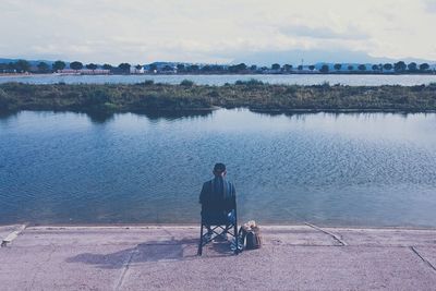 Rear view of woman sitting on beach