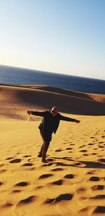 Full length of man on beach against clear sky