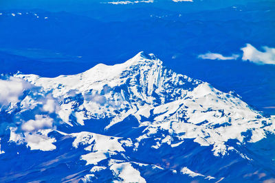 Scenic view of snowcapped mountains against blue sky