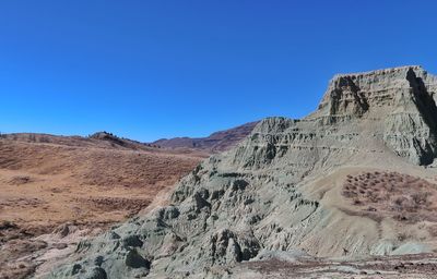 Scenic view of mountains against clear blue sky