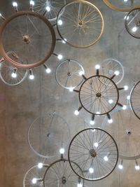 Illuminated light bulbs on wheels against wall