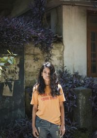 Portrait of woman standing against building