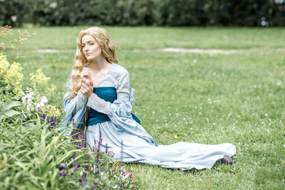 Portrait of young woman sitting on field