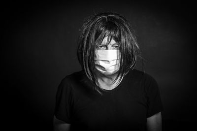 Portrait of young man against black background