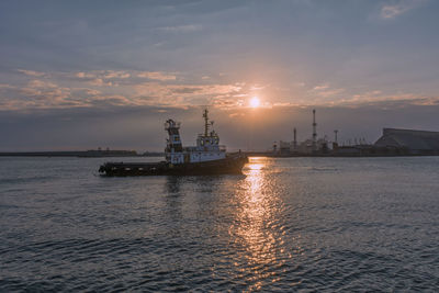 Ship sailing on sea against sky during sunset