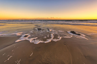 Scenic view of beach against sky during sunset