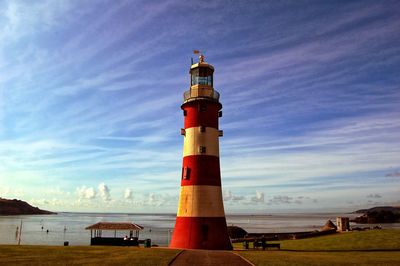 Lighthouse by sea against sky