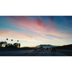 Cars on road at sunset