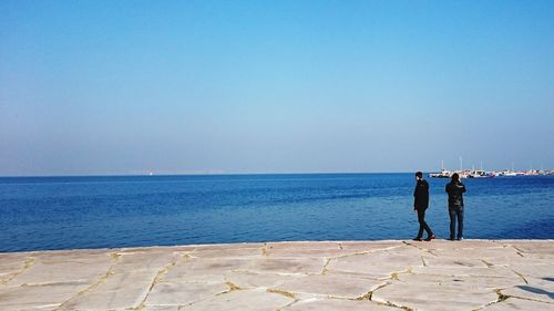 Silhouette of woman standing by sea