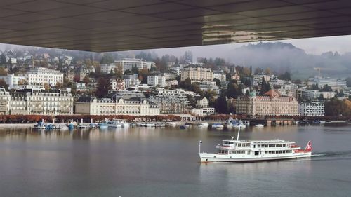 Boats in sea by buildings against sky