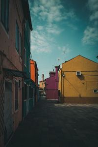 Footpath amidst buildings against sky