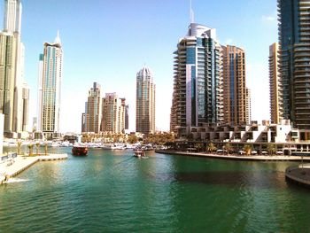 Boats in river with city in background