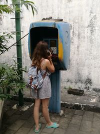 Woman using telephone at booth