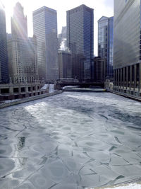 Modern buildings in city against sky during winter