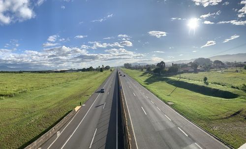 Road amidst field against sky