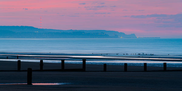 Scenic view of sea against sky at sunrise