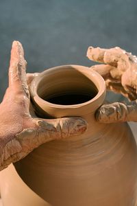 Cropped hand making pottery at workshop