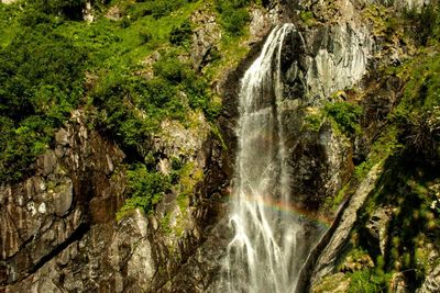 Scenic view of waterfall an rainbow. sunny day