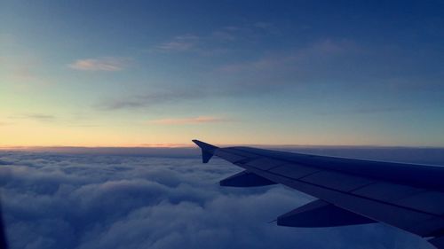 Cropped image of airplane flying over cloudscape