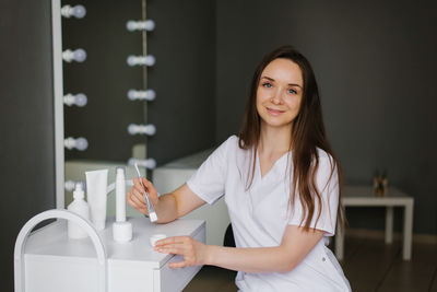 Young woman cosmetologist or dermatologist is sitting in the office of a beauty spa and kneading