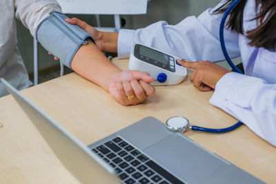 Midsection of man using laptop on table