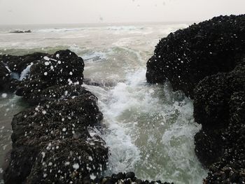 Waves splashing in sea against sky