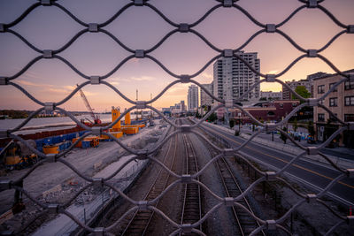 High angle view of railroad tracks seen through chainlink fence