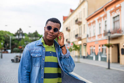 Portrait of young man standing in city