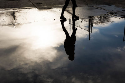 Reflection of man on swing in water