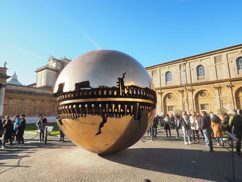 Large reflective ball on street in city