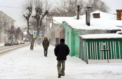 Rear view of man walking in snow