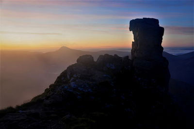 Rock formation against sky during sunset