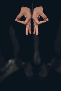 Close-up of woman hand against black background