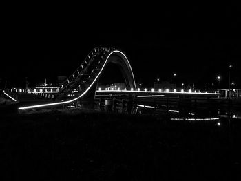 Light trails on bridge over river at night
