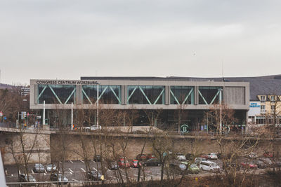 Bridge over river by buildings against sky