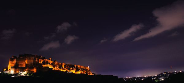 Low angle view of illuminated buildings against sky at sunset