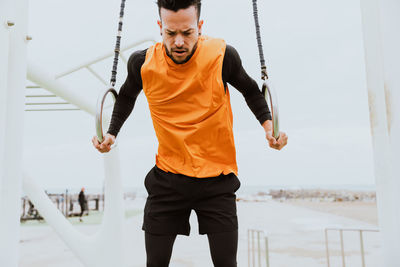 Man exercising against sky