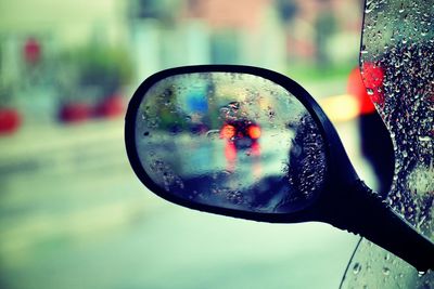 Reflection of man on side-view mirror