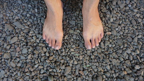 Low section of person standing on pebbles