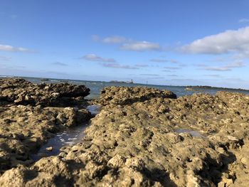 Rocks on beach against sky