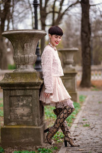 Portrait of woman standing against tree