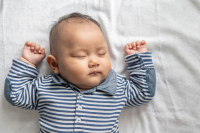 High angle view of baby lying on bed