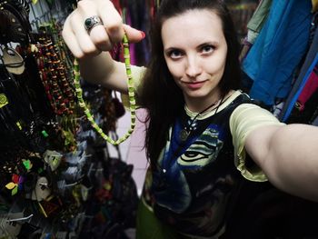 Portrait of woman holding necklace at market